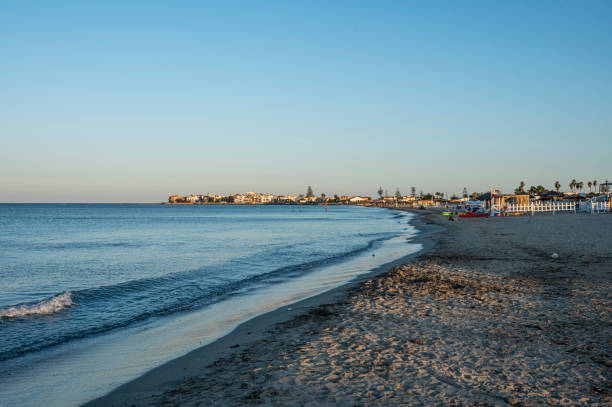 The most beautiful beach in Marzamemi with the city in the background stock photo