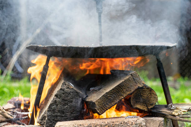 istock Black frying disk on a wood fire, with red flames 1430685595