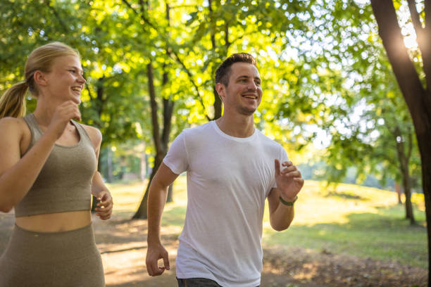 istock Young couple jogging together in a public park 1430688486
