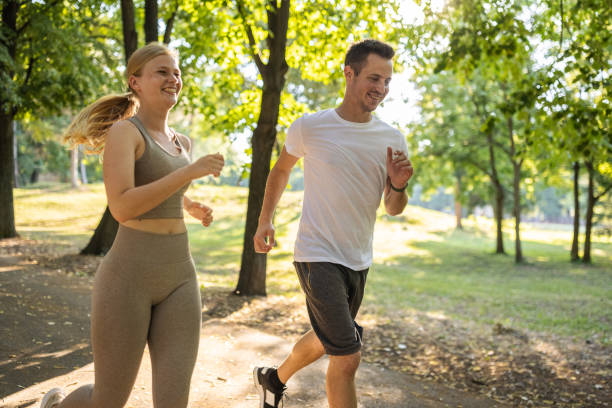 istock Young couple running together in a public park 1430688776