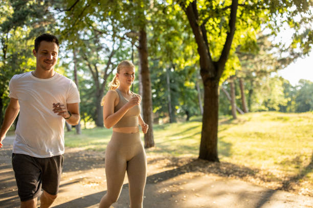 istock Young couple running together in a public park 1430688962