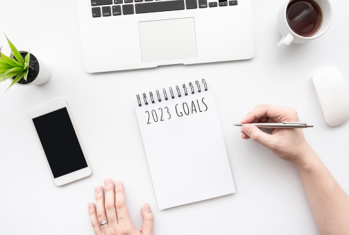 Man is writing 2023 goals for new year resolutions plan.