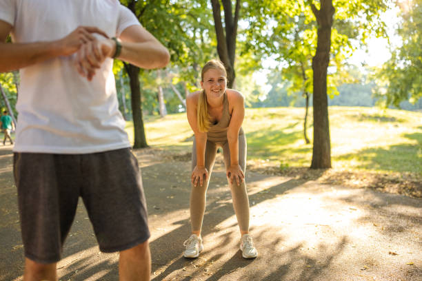 istock Young couple resting after a run in a public park 1430689653