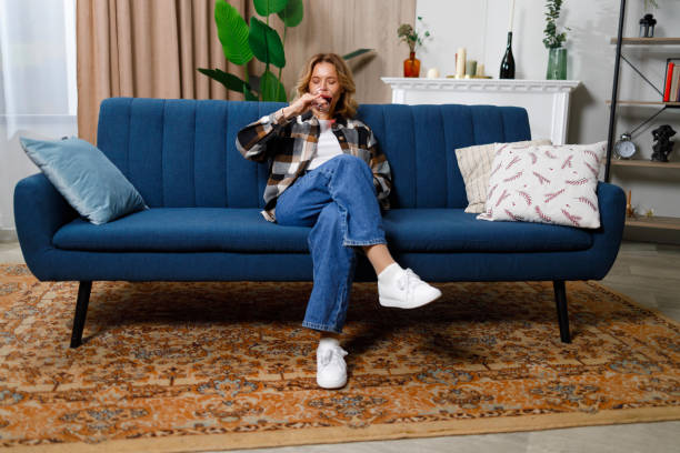 istock Mature woman drinking red wine sitting on sofa 1430703615
