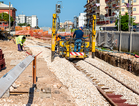 Modugno, Italy - 1 april 2019: Construction workers at work at Railway station. Construction of a new railway line at a city station.