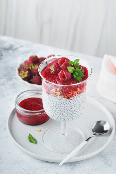 istock Chia pudding. Healthy vanilla chia pudding in glass with fresh raspberries and mint on white background. Vegan healthy breakfast. 1430705734