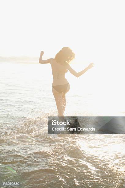Foto de Mulher Andando Nas Ondas Na Praia e mais fotos de stock de Dançar - Dançar, Sensualidade, 30 Anos