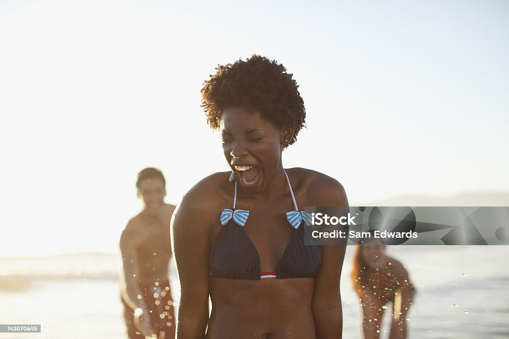 Amigos jugando en las olas en la playa - Foto de stock de Playa libre de derechos