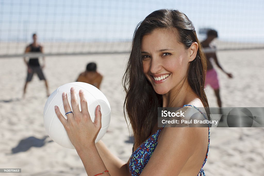 Mujer jugando voleibol de playa con amigos - Foto de stock de 20-24 años libre de derechos