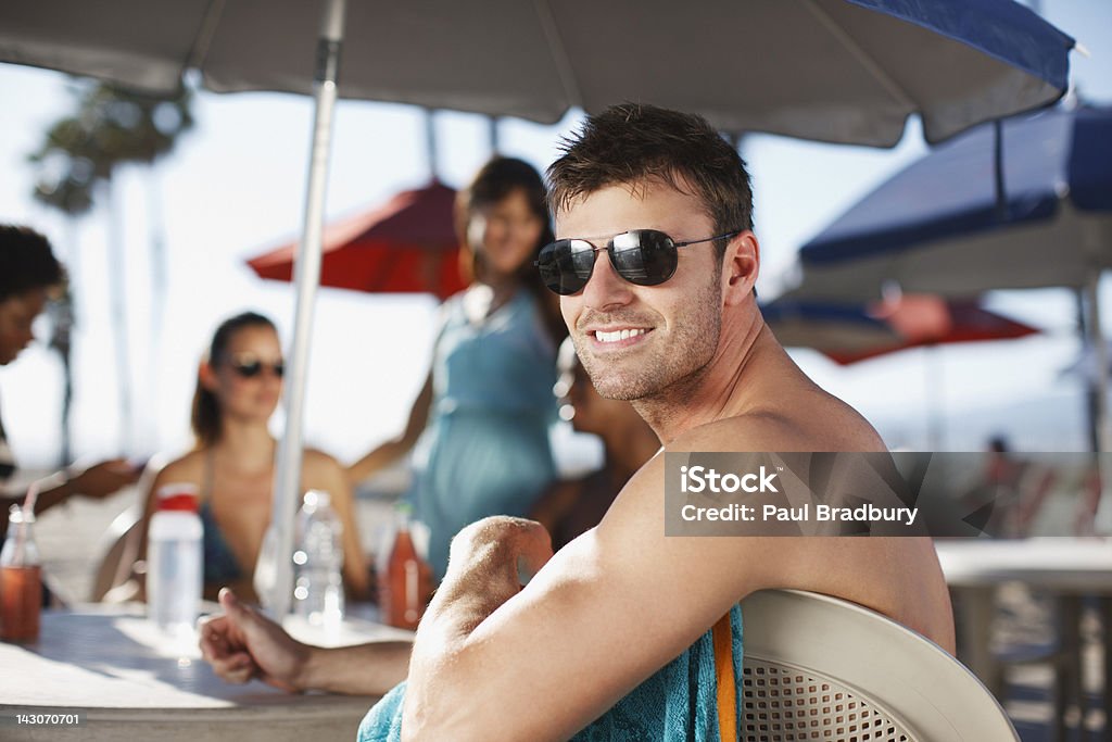 Smiling man sitting at table outdoors  Shade Stock Photo