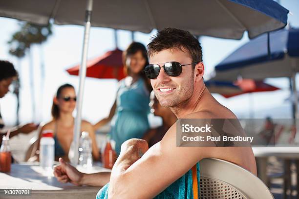 Smiling Man Sitting At Table Outdoors Stock Photo - Download Image Now - Shade, 20-24 Years, 25-29 Years