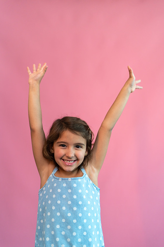 Portrait of a girl with arms raised
