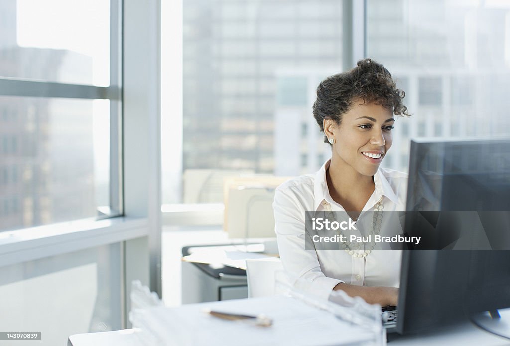 Businesswoman working at desk in office  Using Computer Stock Photo