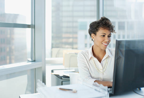 businesswoman working at desk in office - 個人電腦 個照片及圖片檔