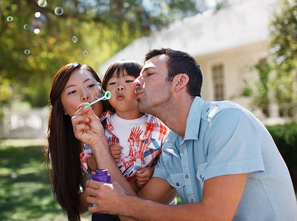 ご家族ご一緒に屋外で告発泡 - bubble wand child blowing asian ethnicity ストックフォトと画像