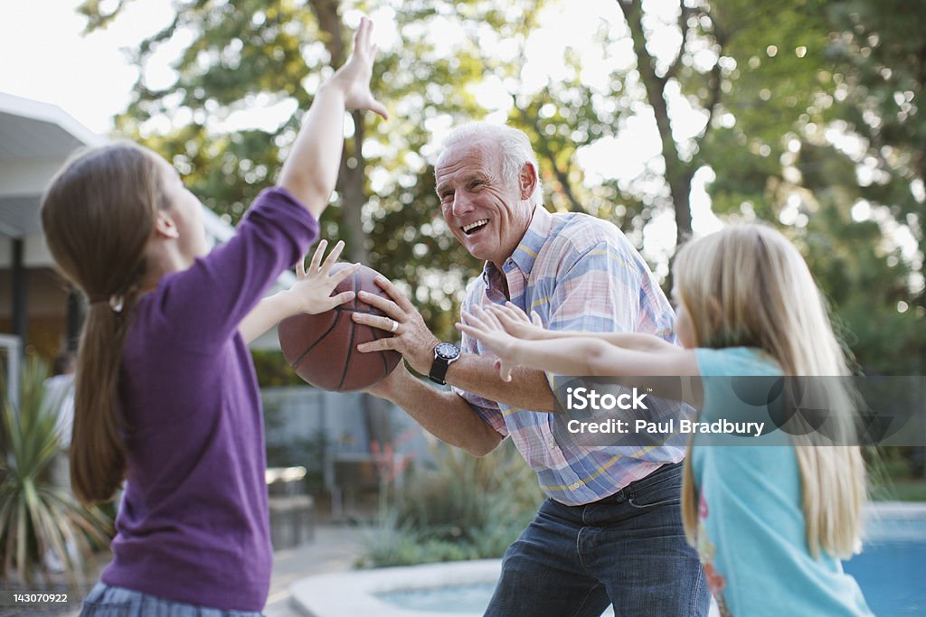 Más hombre jugando al básquetbol con granddaughters - Foto de stock de Tercera edad libre de derechos