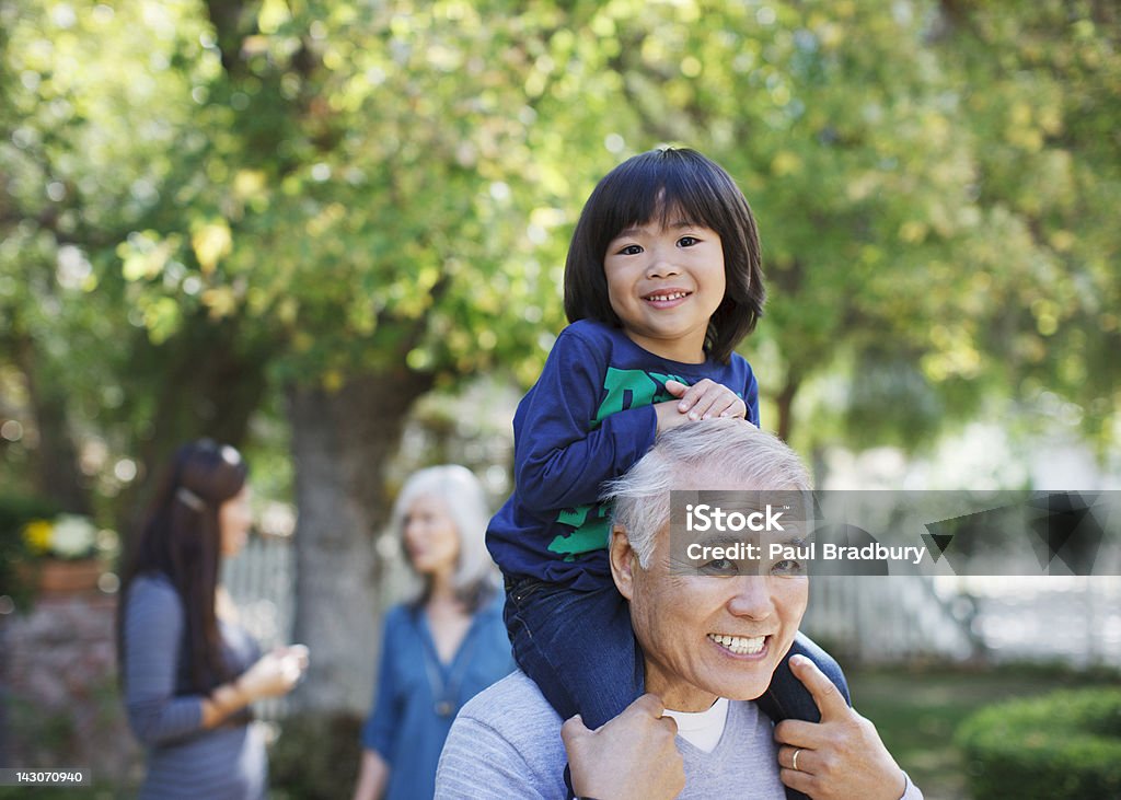 Anziani uomo portare nipote sulle spalle - Foto stock royalty-free di Terza età