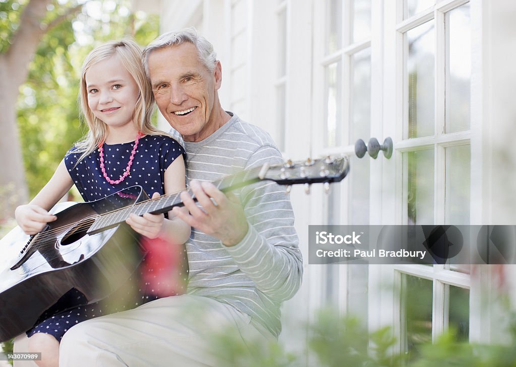 Hombre mayor envenenado y granddaughter tocando la guitarra - Foto de stock de 8-9 años libre de derechos