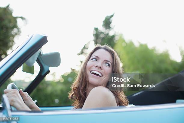 Donna Sorridente Seduto In Auto Convertibile - Fotografie stock e altre immagini di Donne - Donne, Solo una donna, Automobile