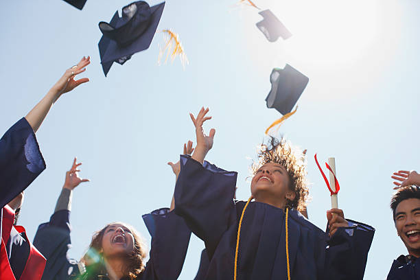 graduados tossing tapas en el aire - graduaciones fotografías e imágenes de stock