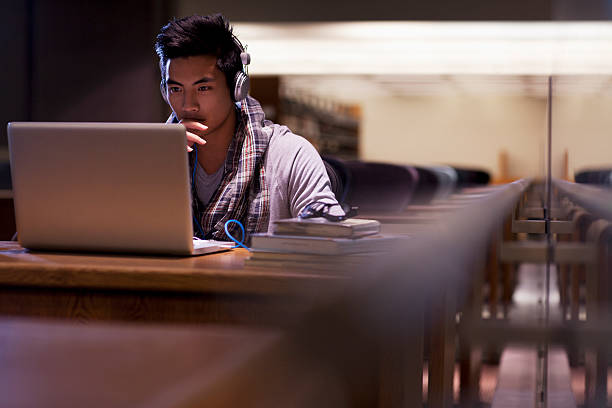 uczeń pracuje na laptopie w bibliotece - college student student asian ethnicity high school student zdjęcia i obrazy z banku zdjęć