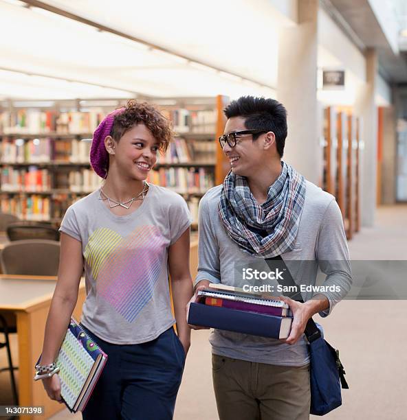 Ritratto Di Un Sorridente Studenti Parlando In Libreria - Fotografie stock e altre immagini di Studente universitario