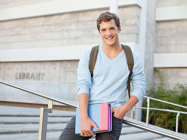 étudiant debout sur les marches en plein air - learning male studying smiling photos et images de collection