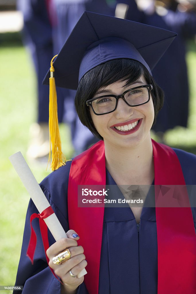 Smiling graduate holding diploma  Holding Stock Photo