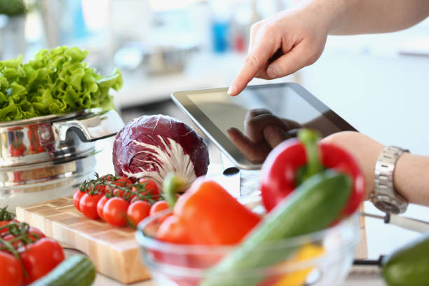 istock Person holding digital tablet and fresh vegetables in kitchen 1430716826