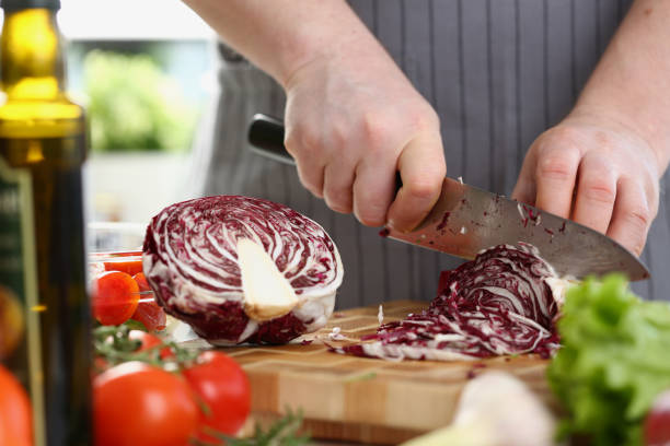 istock Cutting red cabbage with knife on cutting board in kitchen 1430716863