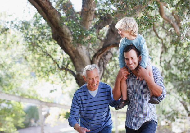 de tres generaciones de hombres caminando al aire libre - three person family fotografías e imágenes de stock