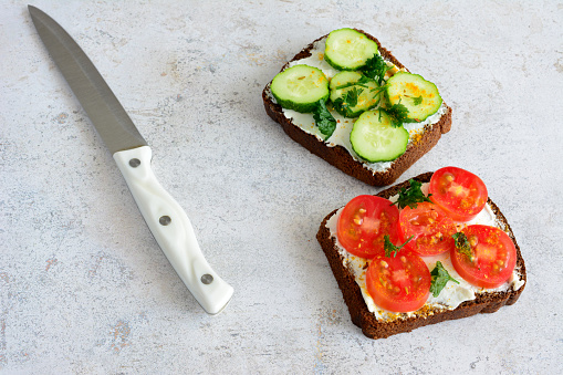 healthy sandwiches with soft cheese and cucumber and tomato slices isolated, close-up