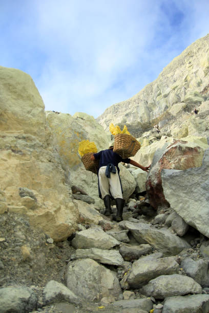 los mineros de azufre en el cráter ijen caminan por la pared de la caldera hasta 300 a 500 metros - as bari fotografías e imágenes de stock