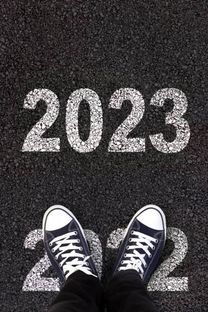 New year 2023 2023 and 2022 written on fresh asphalt with man's feet new year new life stock pictures, royalty-free photos & images