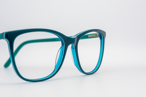 Eyeglass frames, lenses, various colors, both metal and plastic, on a beautiful colored background.