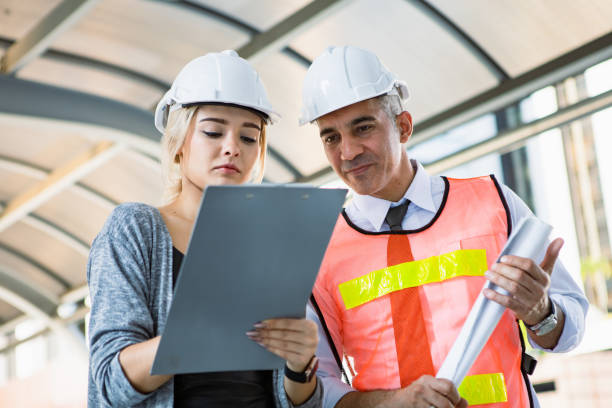 istock Two engineers check the work through a checklist at the job site. 1430731336