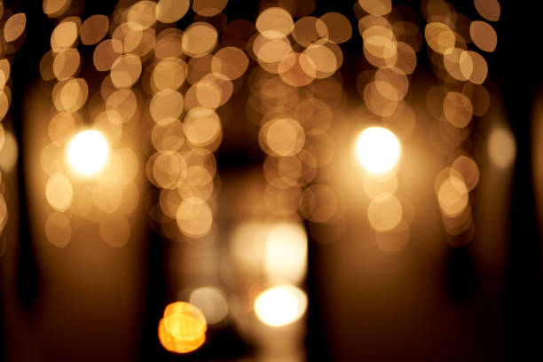 istock Abstract glowing bokeh lights highlighted on a black background. Festive golden glowing background with yellow lights. Overlay bokeh for your design. 1430731956