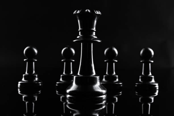 istock Chess figures on dark black background close up 1430733095