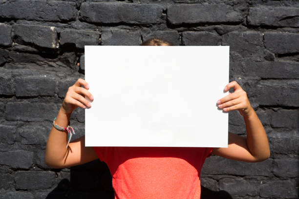 istock Child holding a sign in front of her face 1430733867