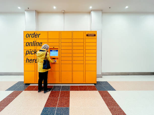 Woman collecting goods from Amazon locker in the city stock photo