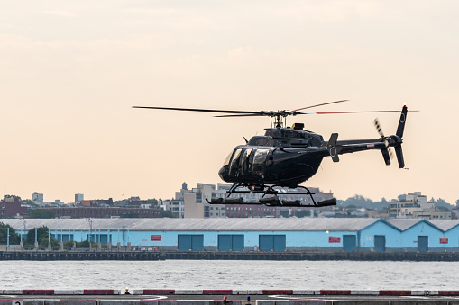 Helicopter over helipad on east river manhattan to pick up passengers for a ride.