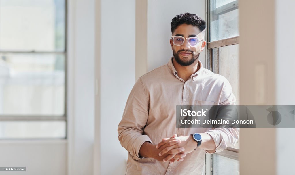 Interior design, ideas and man by house window with innovation idea, motivation and creative vision for property. Portrait, smile or happy Indian designer with success mindset for real estate staging 20-29 Years Stock Photo