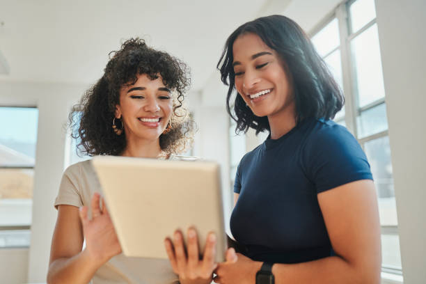 istock Women, tablet and digital marketing teamwork with creative strategy, kpi data analysis and target audience research. Smile, happy or success brazilian business people with technology in collaboration 1430735916