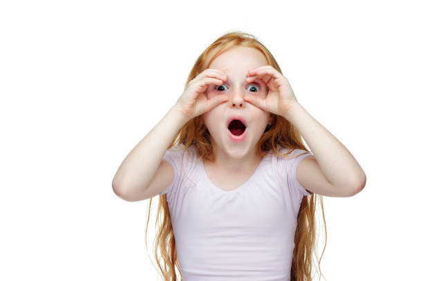 istock Red haired girl making binoculars with her hands 1430736305