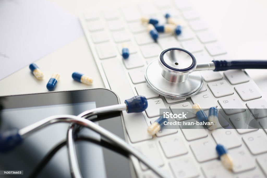 Tablets and stethoscope on computer keyboard closeup Tablets and stethoscope on computer keyboard closeup. Ordering medical pills drugs online on Internet Allergy Stock Photo