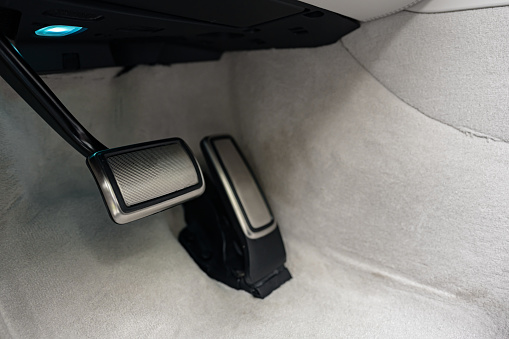 Brake and gas pedals of a luxury car close up