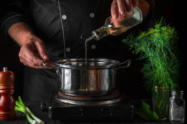 istock The chef adds oil to saucepan while making dumplings. Working environment on vintage kitchen table in restaurant. 1430738059