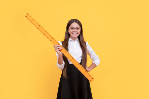istock cheerful kid in school uniform and glasses hold mathematics ruler for measuring, geometry 1430738806