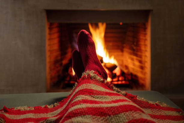 istock Man covering with blanket enjoys the calmness next to burning fireplace. 1430740135