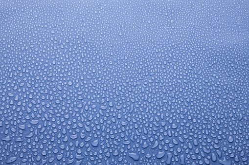 Tiny water droplets on light violet or very peri background as dew or spray pattern with gradient color, top view.